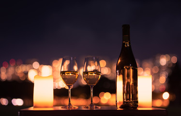 Candlelight dinner with wine and romantic city view.