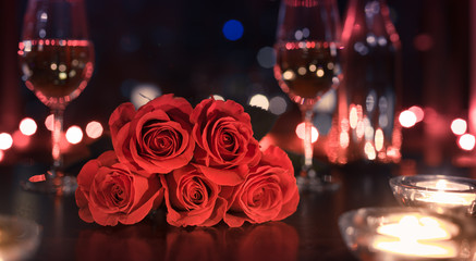 Gift of red roses and candle light dinner. Dinner date night and Valentines Day concept. 