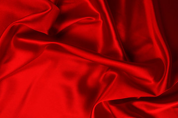 Red silk or satin luxury fabric texture can use as abstract background. Top view.