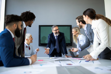 Group of business people discussing, brainstorming in office. Concentrated at work.