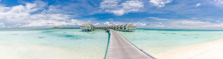Panoramic landscape of Maldives beach. Tropical panorama, luxury water villa resort with wooden pier or jetty. Luxury travel destination background for summer holiday and vacation concept.