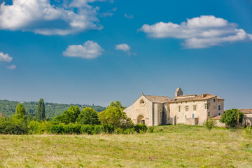Fototapeta na wymiar Salagon - tourist destination, Provence, France, famous for herbal, medicinal plants. Traditional stony church tower in the countryside of Provence Alpes Cote d Azur, France, a sunny day with blue sky