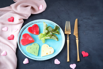 Red pepper and cheese salad in the form of hearts for breakfast on Valentine's Day. Serving a festive meal with a fork and knife.