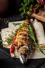 Georgian cuisine. Grilled mackerel fish with vegetables and rosemary. Serving dishes in a Georgian restaurant. background image, copy space