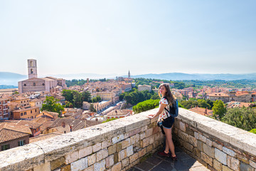 Fototapeta na wymiar View in Perugia, Italy in Umbria cityscape of Church of San Domenico tower and rooftops of town village in summer landscape with woman at overlook