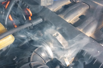 Smoke under the hood of car. Car engine smokes.