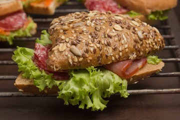 Sandwich with meat and greens, a bun with grains. Tasty breakfast. .