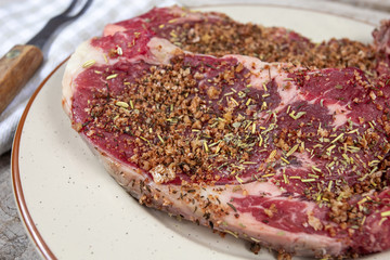 entrecôte de boeuf crue avec des épices et du sel dessus