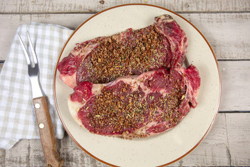 entrecôte de boeuf crue avec des épices et du sel dessus