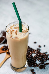 Iced latte fresh coffee put on the stone table with bean and powder coffee. Fresh drink with good raw material for good taste.