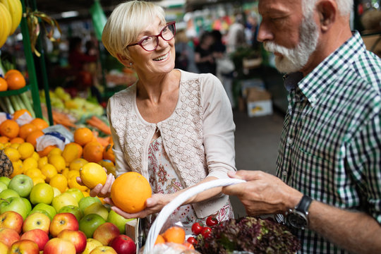 Mature couple shopping vegetables and fruits on the market. Healthy diet.