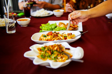 Families eating food together who are happy to eat many cuisine on the table