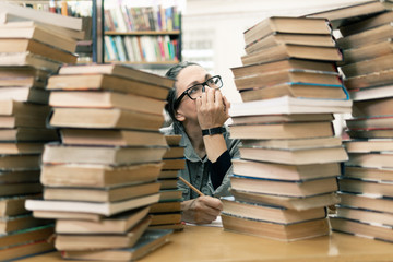 woman in the library in front of bookshelves. Concept of education