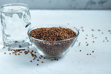 Buckwheat raw, medium rare. Measured for making porridge. On a gray background under concrete.