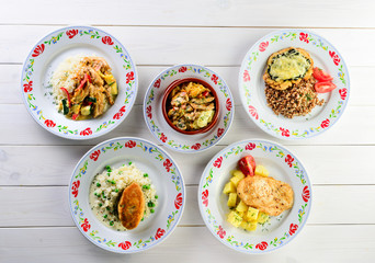 set of homemade food in plates on a white wooden table