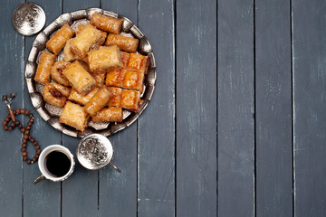Top view of big metal tray with turkish baklava on planked wooden table