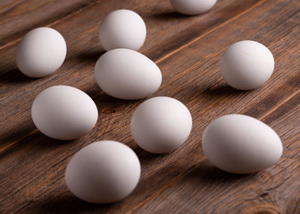 Raw eggshells in a white shell. Chicken eggs on a wooden table. Inshell natural chicken eggs on wooden background.