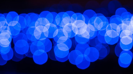 Dark background with blur blue light circles. Abstract defocused pattern