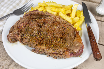 entrecôte de boeuf grillée et frites dans une assiette