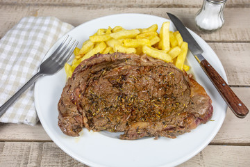 entrecôte de boeuf grillée et frites dans une assiette