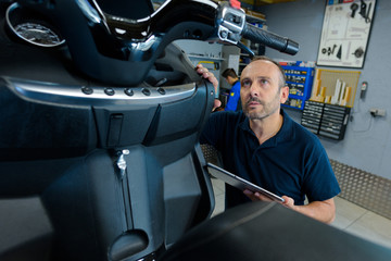 motorcycle and scooter mechanic checking the vehicle © auremar
