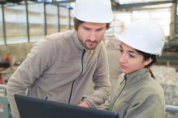 workers in a recycle center looking at laptop
