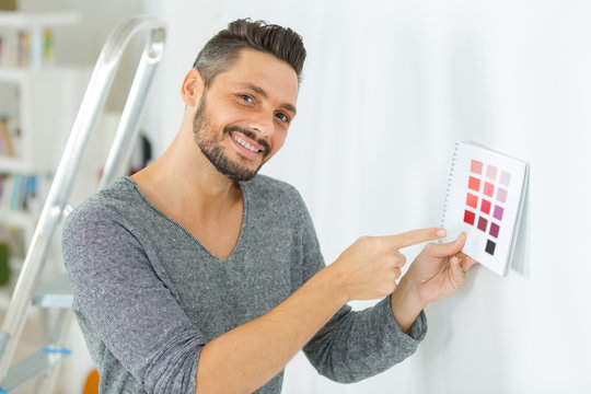 man holding samples for choosing color of wall