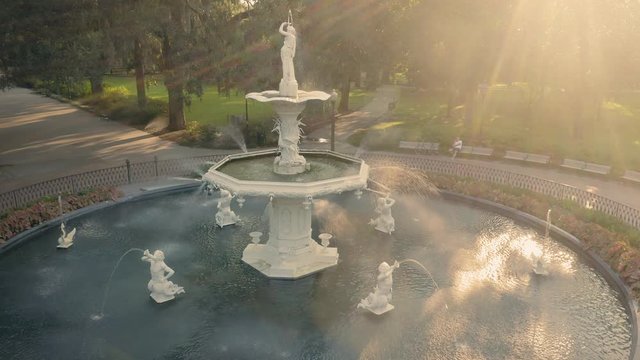 Aerial:  Fountain & oak trees with rays of light shining through. Forsyth Park. Savannah, Georgia, USA.