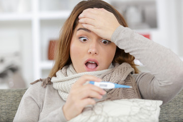 surprised and shocked woman looking at temperature