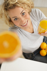 woman with juice glass and oranges on wooden background