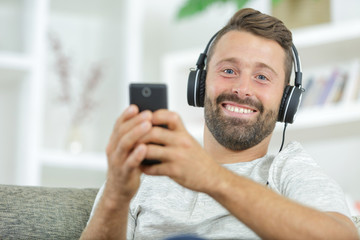 man with mobile phone and headphones at home