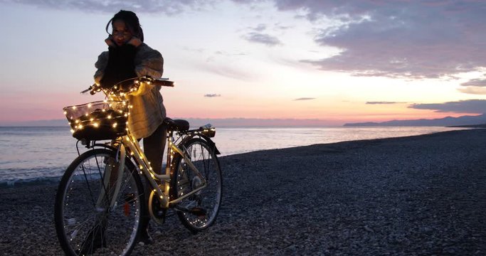 San Valentino, la festa degli innamorati. Ragazza da sola in bici la notte vicino al mare