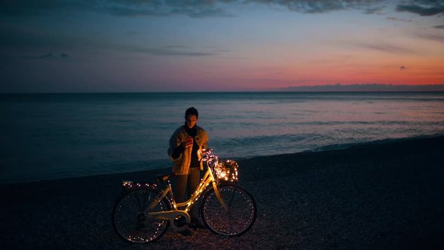 San Valentino, la festa degli innamorati. Ragazza da sola in bici la notte vicino al mare