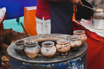 Earthenware pots in line at market tea stall