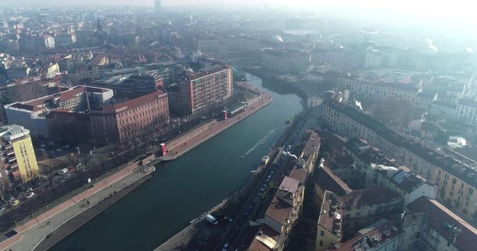 Aerial view of Milan (Italy) in winter day with haze. Flying forward over the Milano Darsena Navigli district. The Darsena (the ancient dock of Milan) was redeveloped in 2015.