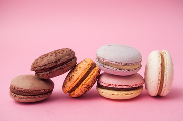Closeup of french macarons pile on pink background