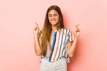 Young slim woman crossing fingers for having luck