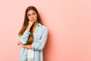 Young slim woman who feels sad and pensive, looking at copy space.