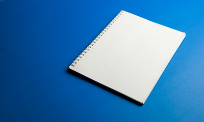 Open a notebook with the top view of the blue table, with the blank note. flat office concept