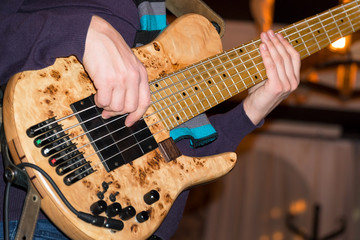 Fototapeta premium The bass player plays a five-string bass guitar close-up. Plays bass guitar. Selective focus