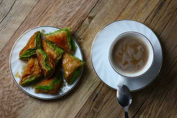 top view of breakfast with a cup of coffee and sweet cakes on a wooden table