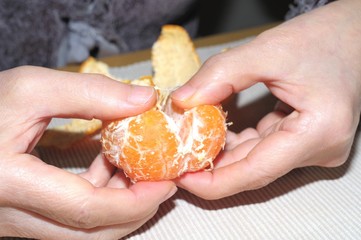 ミカンを食べている高齢の女性