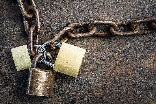 Triple Locked Padlocks, linked for shared access, security background on rusted steel plate.
