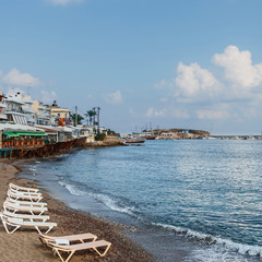 sun loungers and umbrellas on a sandy beach in the Greek resort town of Hersonissos