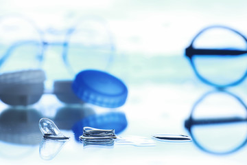 Tools for vision correction. Glasses and lenses with diopters on the background of splashes and...