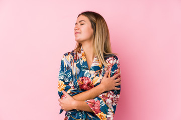 Young caucasian woman wearing pajamas hugs, smiling carefree and happy.