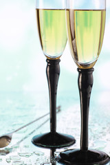 Background with tall glasses for sparkling wines. Champagne and spray in glass glasses. Celebratory drink with reflection.