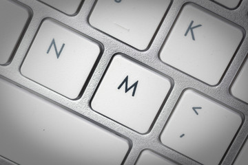 Computer keyboard - silver keyboard of a laptop with button M isolated. Home office with portable modern technology, IT and computing.