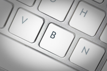 Computer keyboard - silver keyboard of a laptop with button B isolated. Home office with portable modern technology, IT and computing.