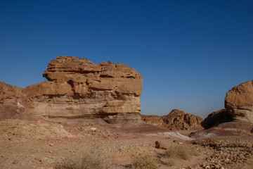 The famous Timna National Park in the desert in southern Israel in the Eilat region. Sand cliffs, dry land, red sand in the form of pillars and mushrooms. Sights of Israel.